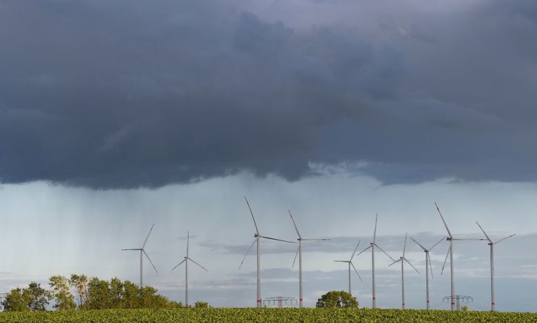 Rain clouds are pictured over power-generating wind turbines near Prenzlau