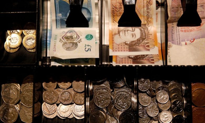 Pound Sterling notes and change are seen inside a cash resgister in a coffee shop in Manchester