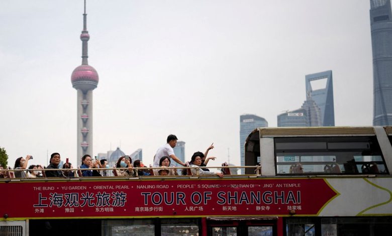 Tourists ride on a tourist double-decker bus in the Bund in Shanghai