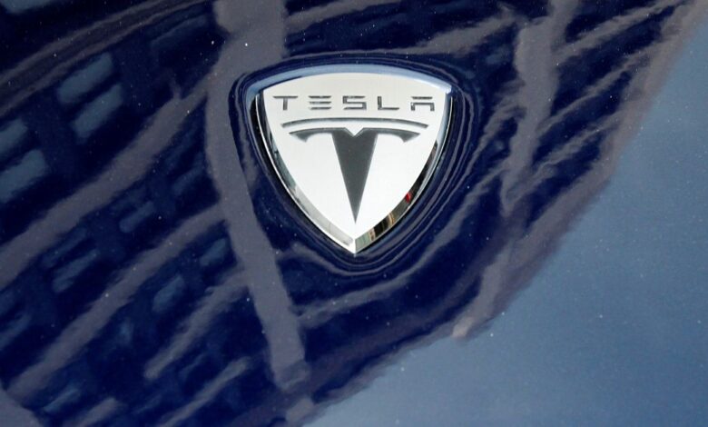 A logo of Tesla Motors on an electric car model is seen outside a showroom in New York