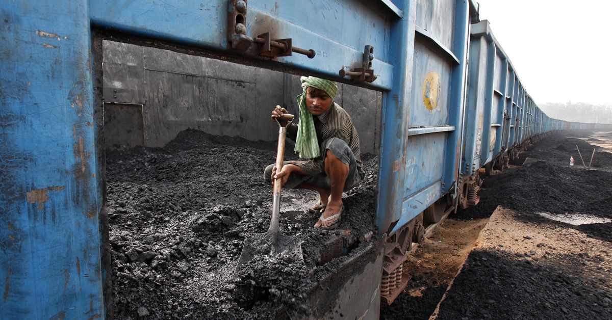 Worker unloads coal from a goods train at a railway yard in Chandigarh