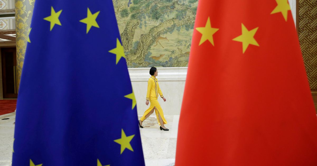 Photo d'archives: Une femme passe devant les drapeaux de l'UE et de la Chine avant le dialogue économique de haut niveau entre l'UE et la Chine à Pékin