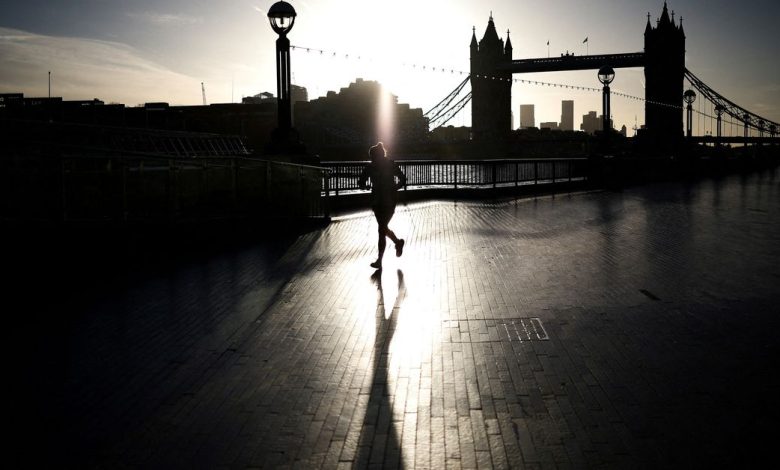 A person jogs alongside the River Thames during sunrise in London