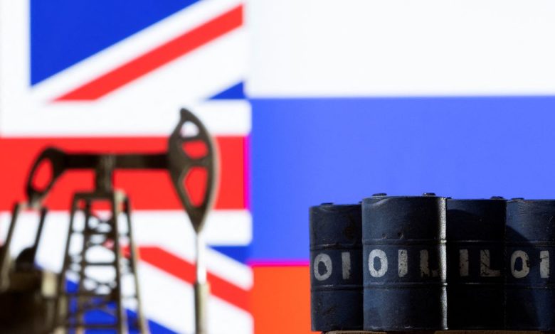 Illustration shows pump jack and oil barrels in front UK and Russia flag colors