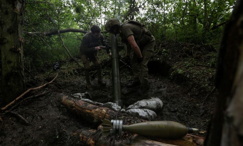 Ukrainian servicemen fire a mortar towards Russian troops near a front line in Donetsk region