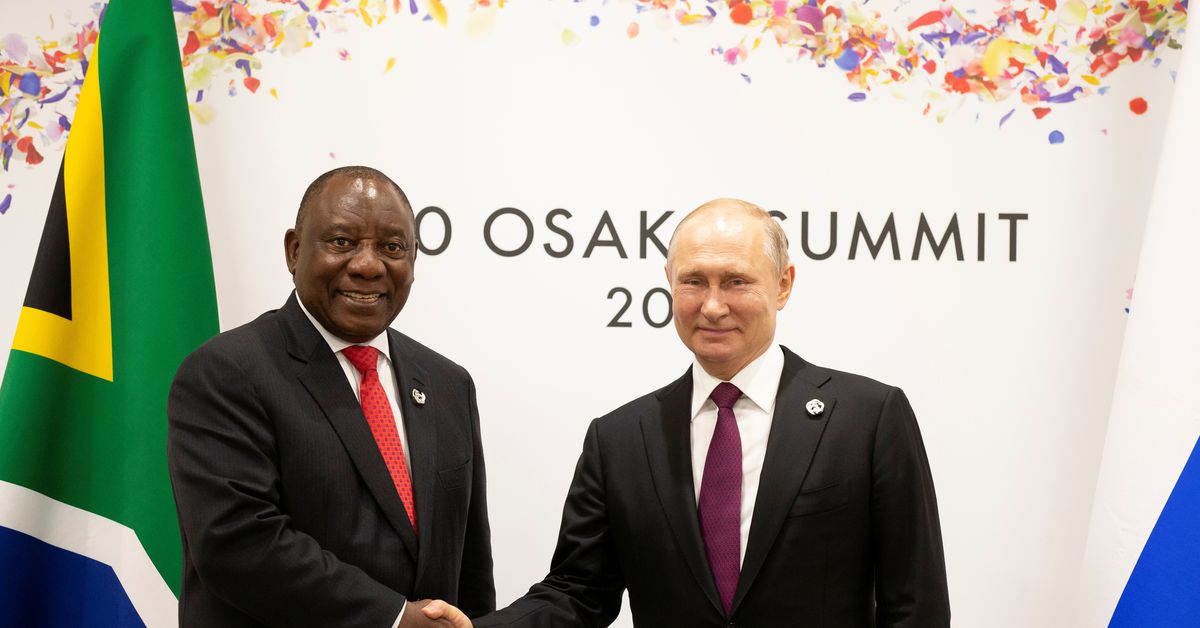 Russian President Vladimir Putin, right, and South African President Cyril Ramaphosa shake hands during their meeting on the sidelines of the G-20 summit in Osaka, western Japan