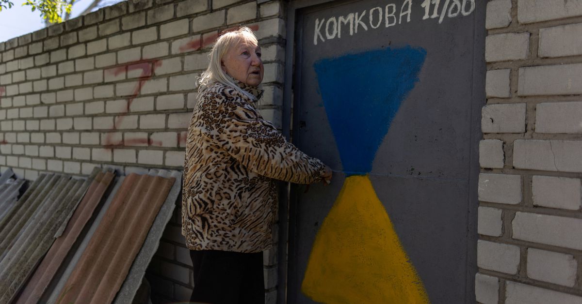 Valentyna Haras stands outside of her home in Kherson