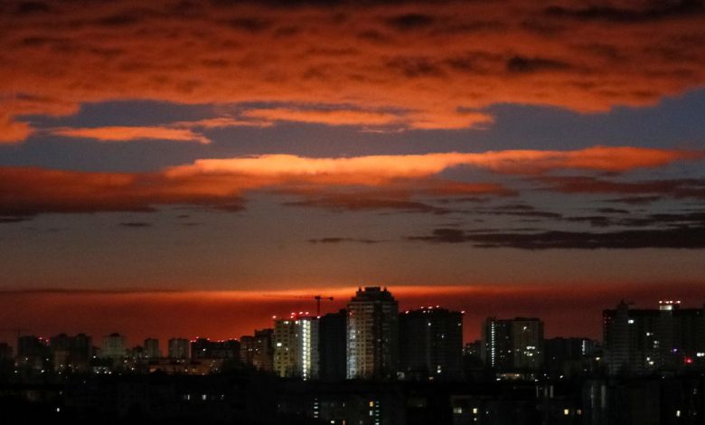 A glow rises over skyline during a shelling in Kyiv