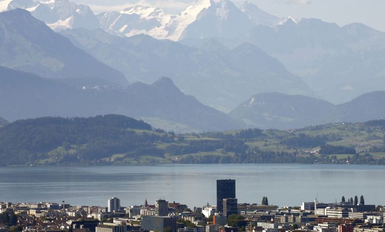 Peaks of Bernese Oberland are seen behind Lake Zug and the city of Zug